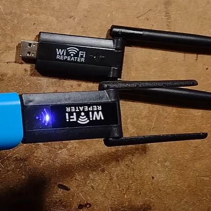 Fake WiFi repeater with a cheap real one behind it. (Credit: Big Clive, YouTube)