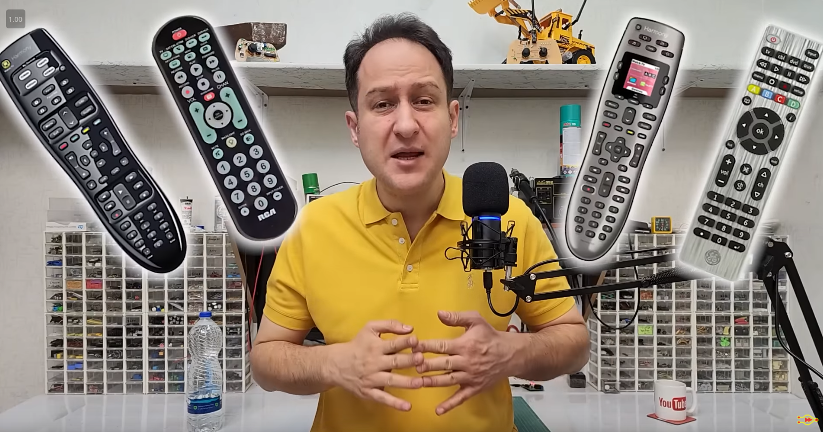 The host stands in his electronics lab with the image of four remote controls overlaid.