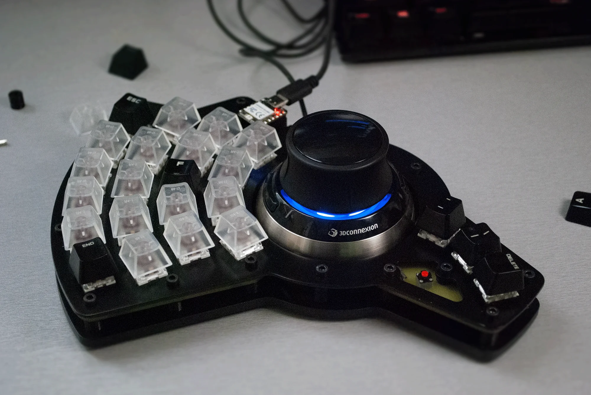 A Spacemouse with an arcing keyboard built around it.