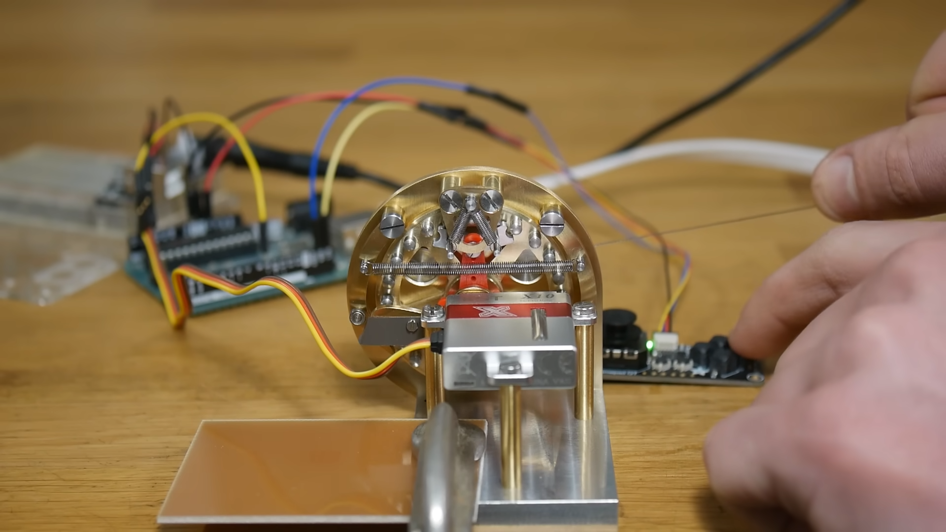 Full picture of tendon pulling actuator with Arduino elements in the backdrop