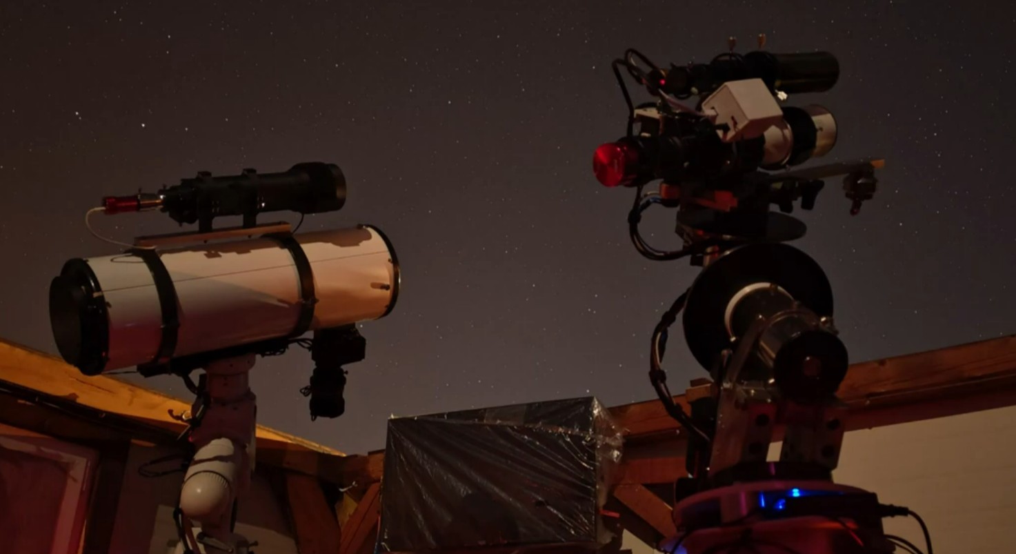 Two telescopes looking into the night sky.