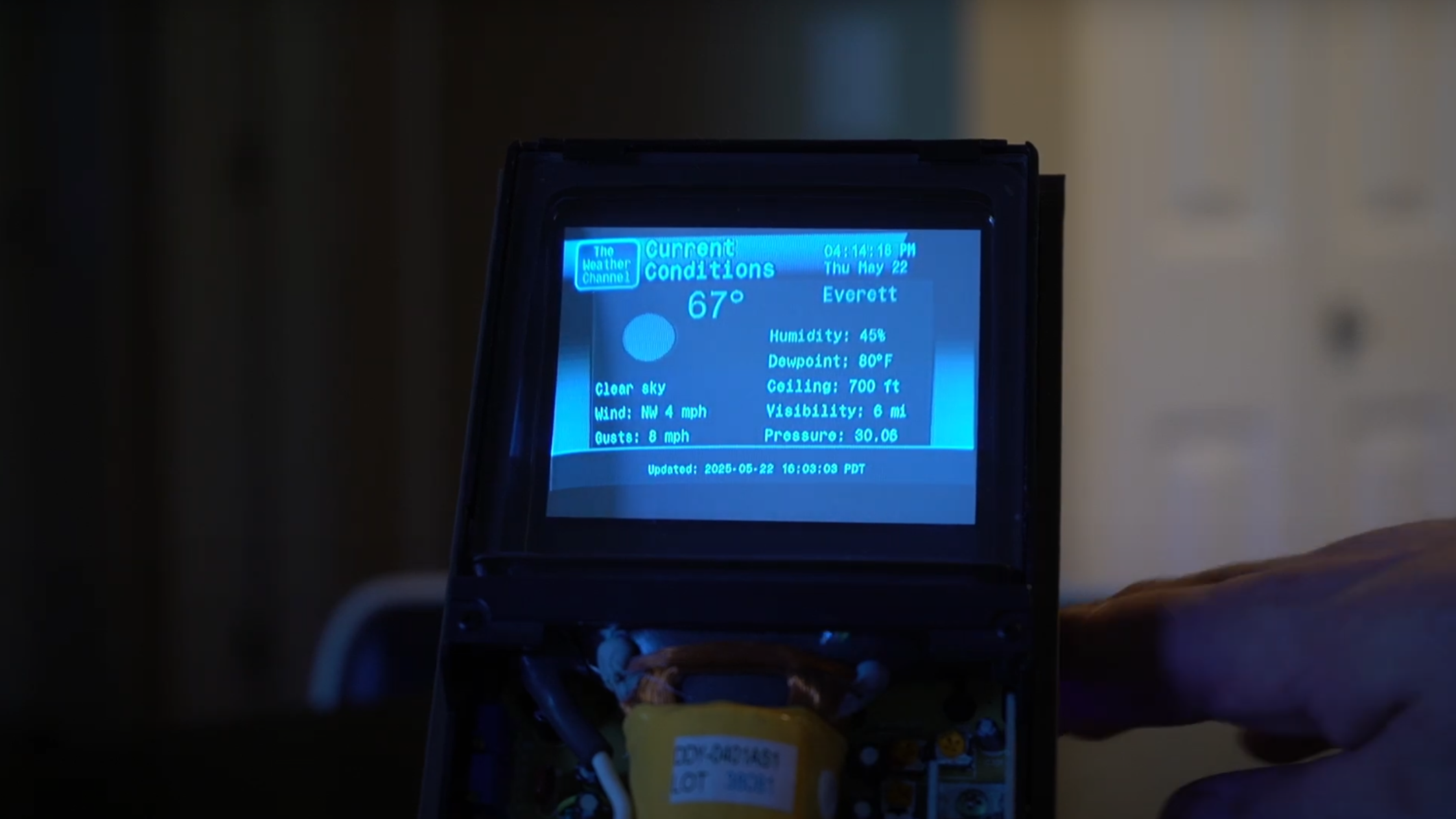 A weather forecast is shown on a blue monochrome cathode ray tube display. It is displaying current conditions, and displays a “The Weather Channel” graphic in the top left corner.