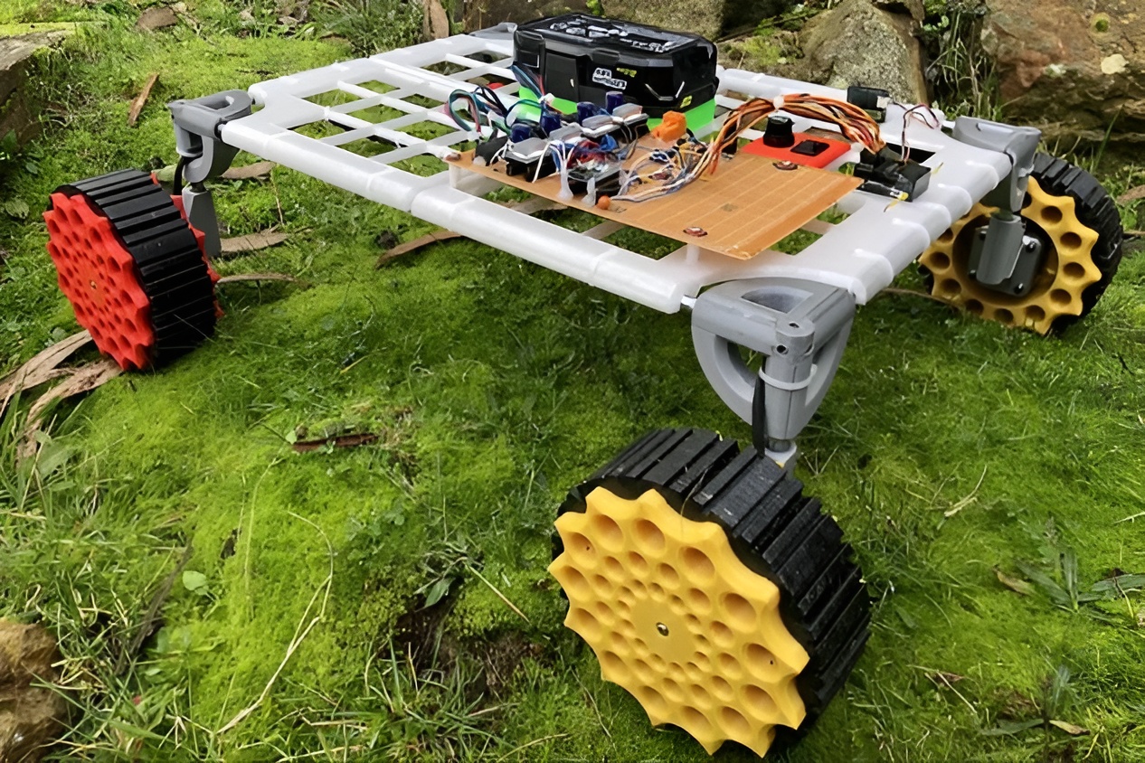 RC rover/car with red and yellow-sided wheels. Electronics are visible on top of vehicle.