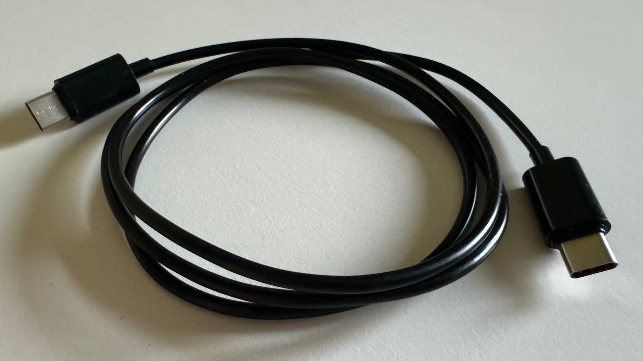 A coiled black USB-C to USB-C cable is shown on a white background.