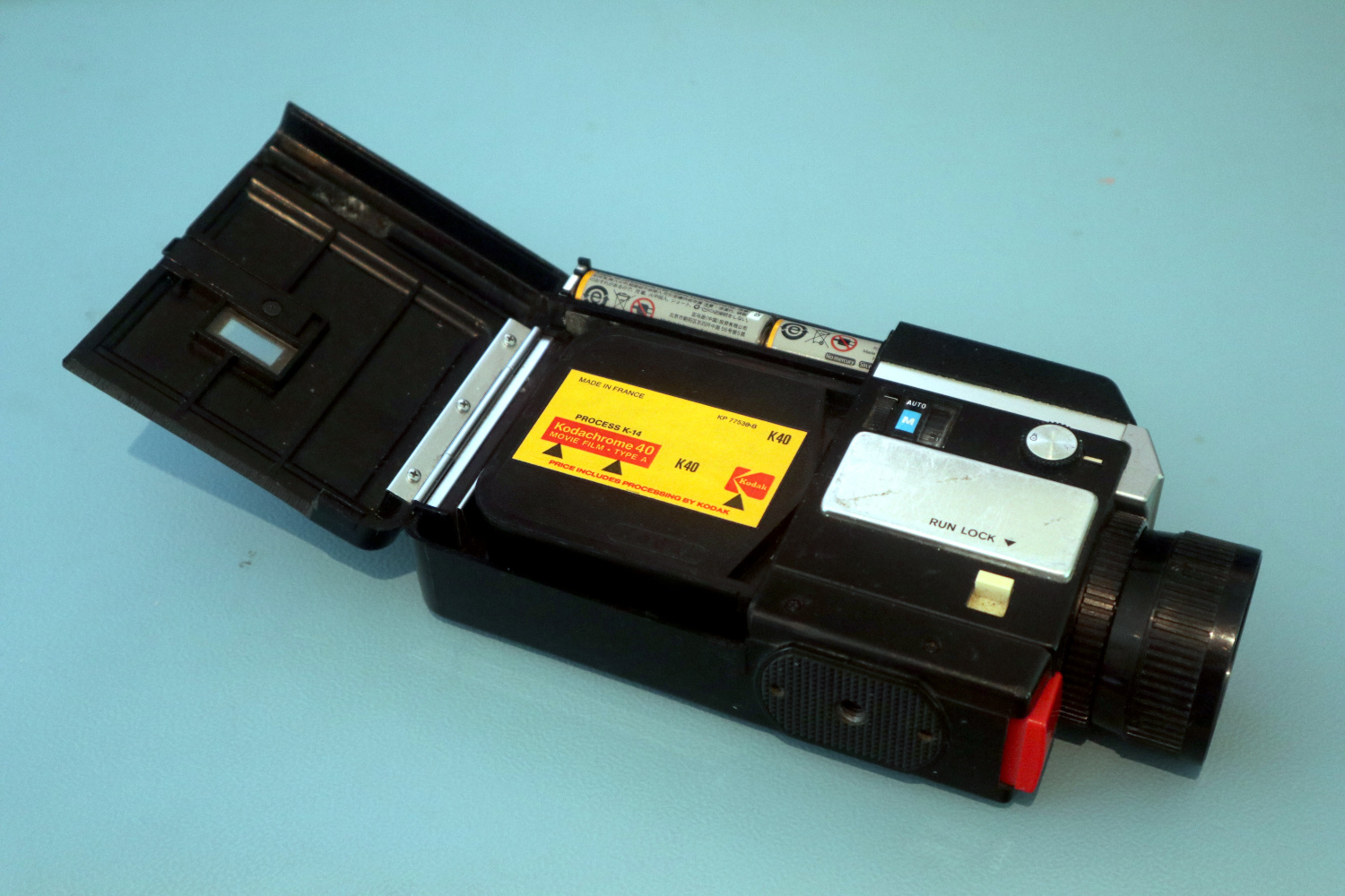 The camera on its side with the cartridge door open, showing a Kodachrome cartridge.