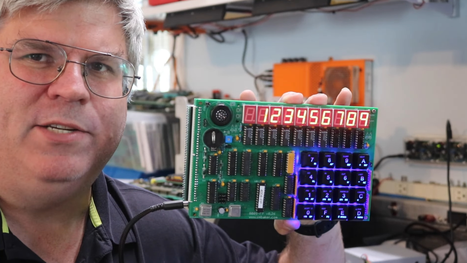 Scott holding the demo board which has a 7-segment display and keyboard attached