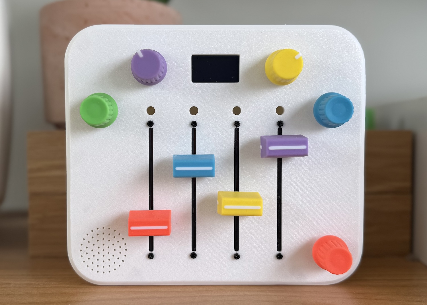 A small, colorful synth built for a 3-year-old. It has five pots, four sliders, and a tiny screen.