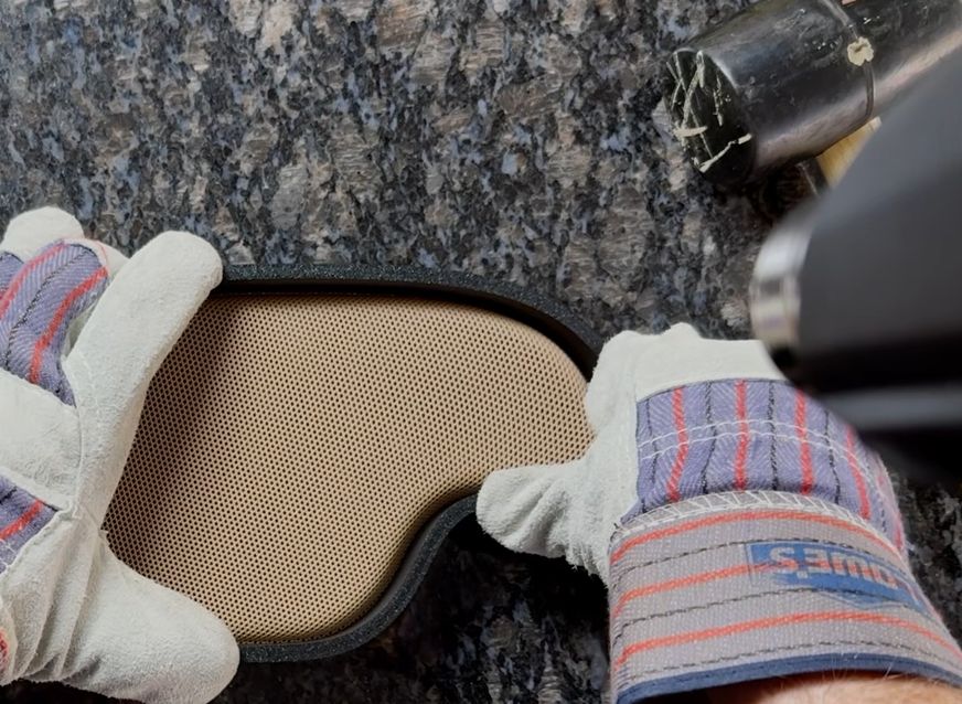 Making sure the heatgun is on 'low' and gloves are on while pushing on the mold. (Credit: Zion Brock)