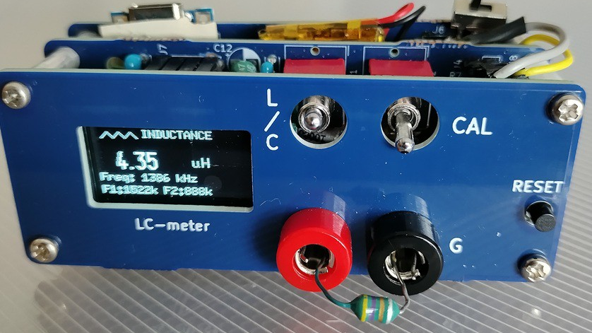 A blue frontplate to a circuit board is shown. On the left side is an OLED screen displaying "4.35 µH". To the right of this are a red and a black socket, with an inductor between them.